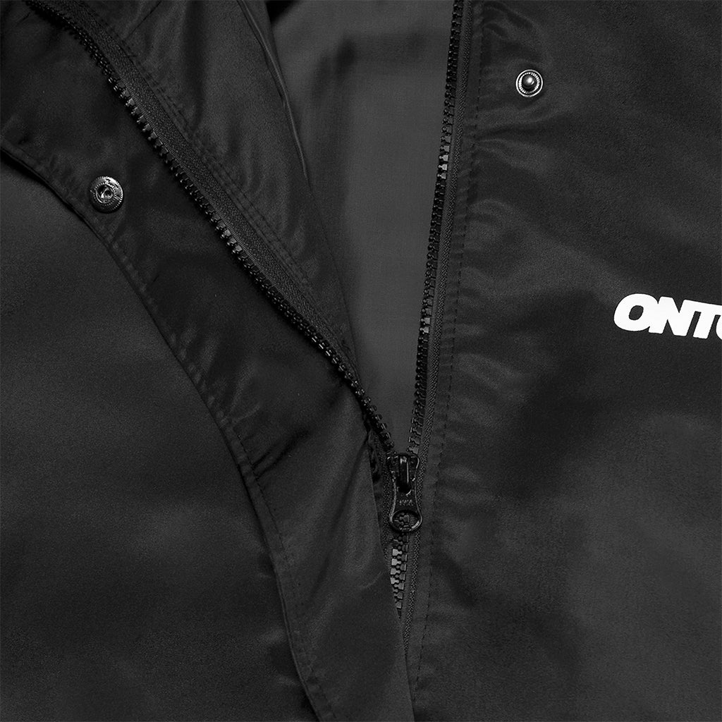 Close-up of a black jacket with a brand logo on the sleeve.