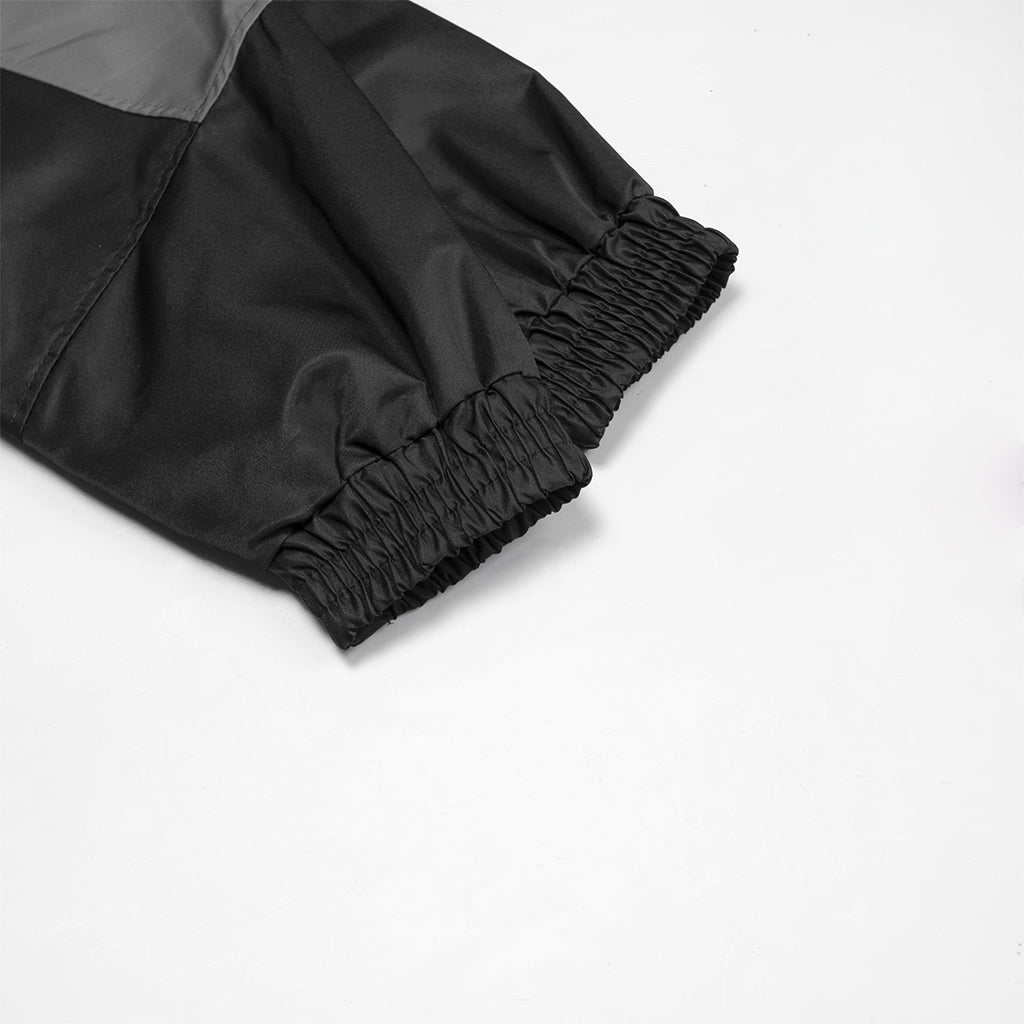 Close-up of black pants with a gray section on a white background