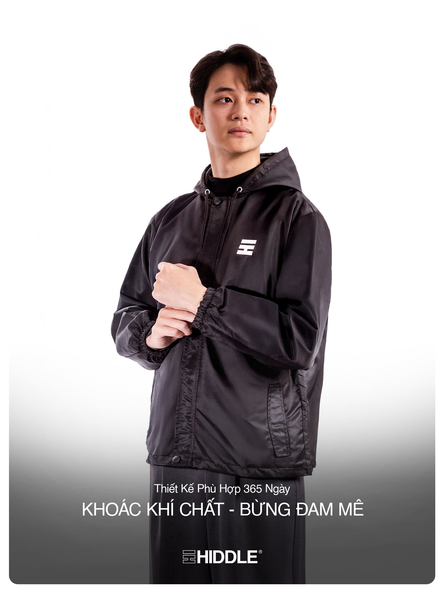 Person wearing a black jacket with a brand logo on a white background