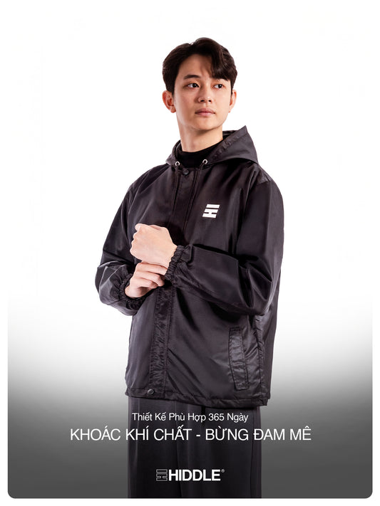 Person wearing a black jacket with a brand logo on a white background