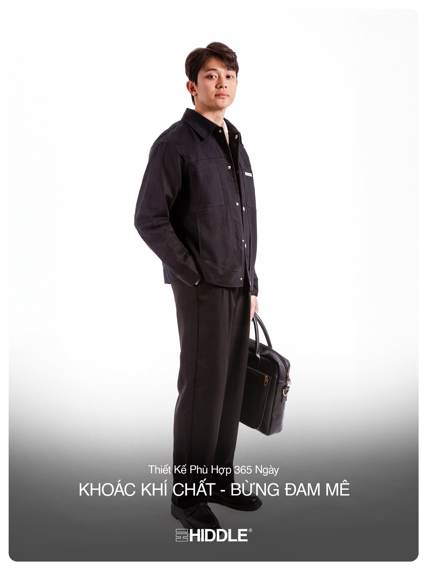 Man wearing a black outfit with a briefcase, standing against a white background, featuring the brand 'Hiddle'.