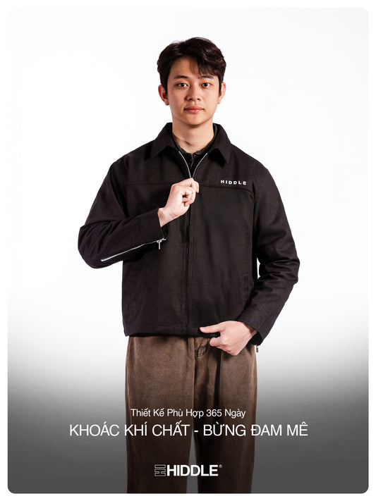 Man wearing a black jacket with 'Hiddle' branding on a white background