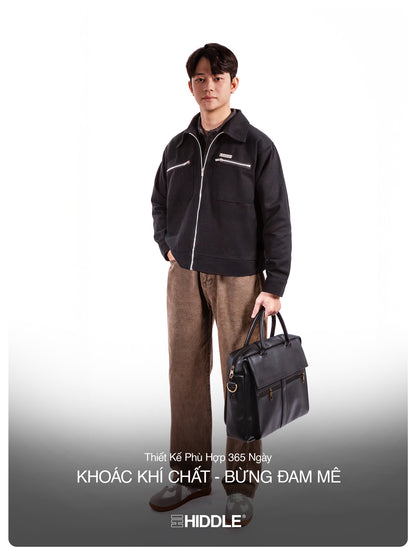 Man wearing a black jacket and brown pants holding a black briefcase on a white background