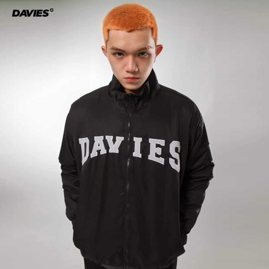 Person wearing a black jacket with 'DAVIES' branding on a gray background