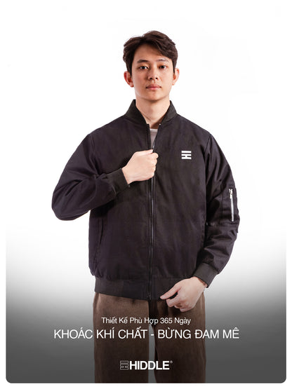 Man wearing a black jacket with a visible brand logo on a white background