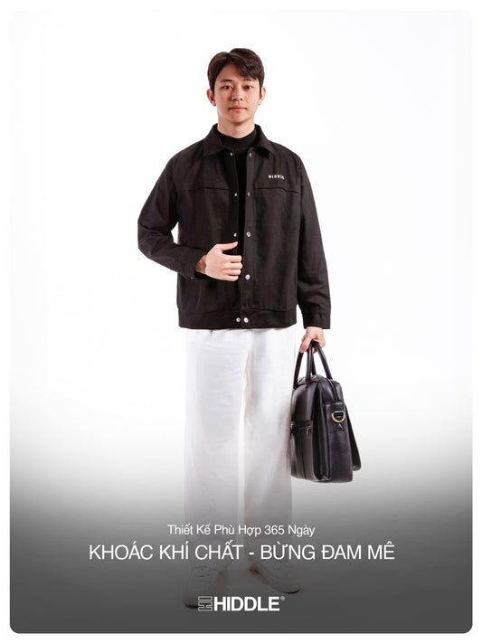 Man holding a black briefcase wearing a black jacket with 'Hiddle' branding on a white background.