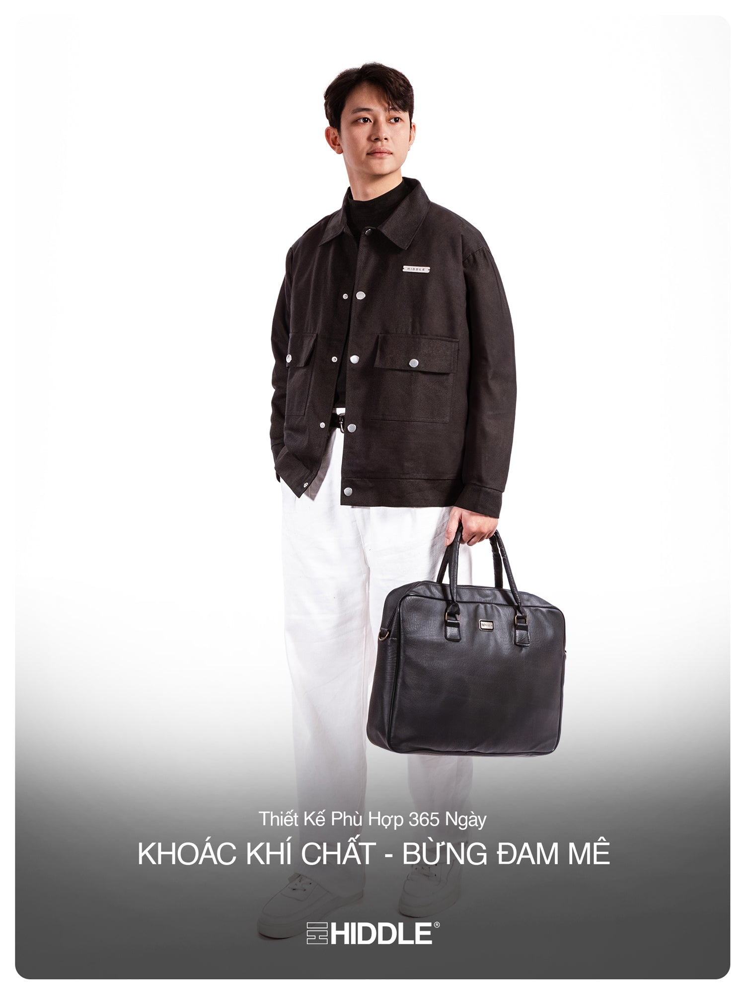 Man holding a black leather bag with Hiddle branding on a white background