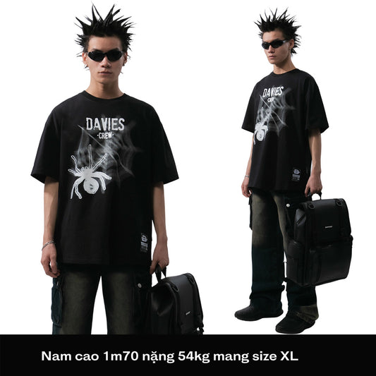 Person wearing a black 'DAVIES' t-shirt with a suitcase on a white background