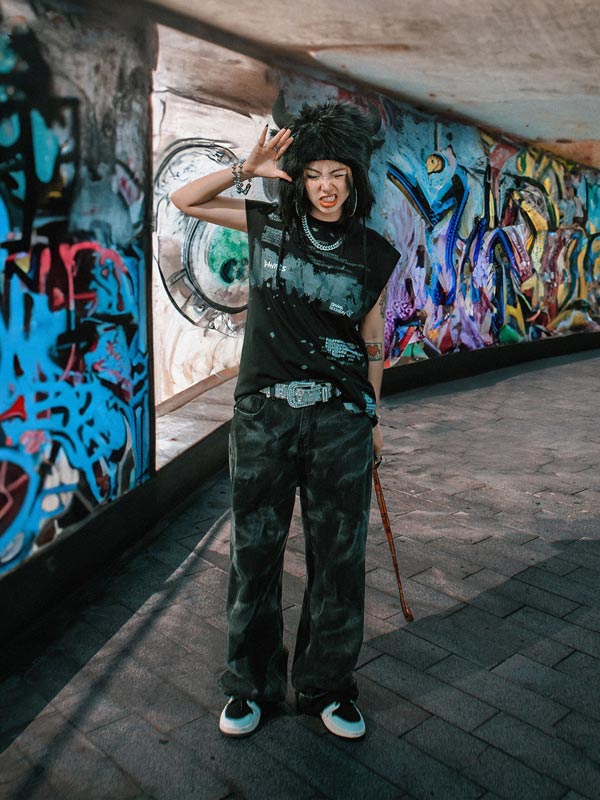 Person standing in front of a graffiti-covered wall