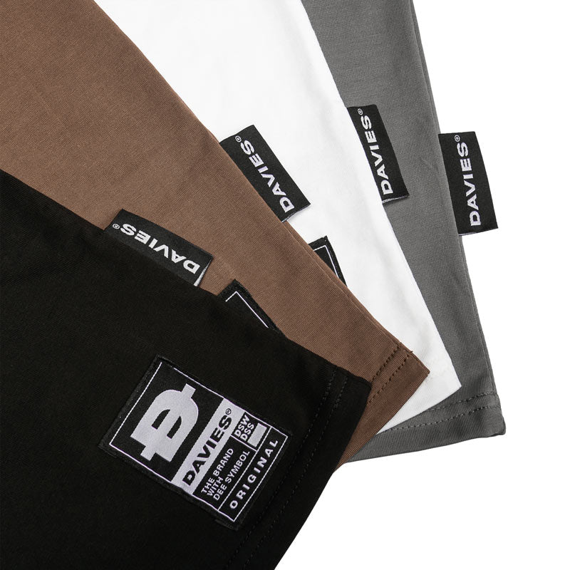 Close-up of folded pants with Davies brand labels on a white background
