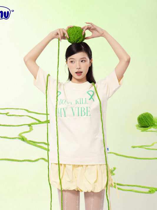 Woman holding a green yarn ball with a light green background