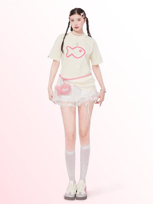 Person wearing a light-colored outfit with a pink fish design on a white background