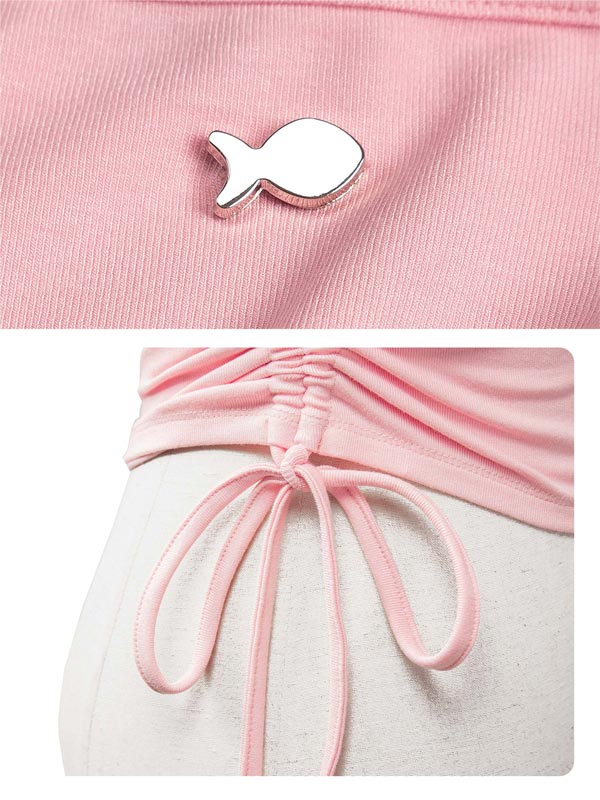 Pink outfit with a fish-shaped brooch and tied waistband