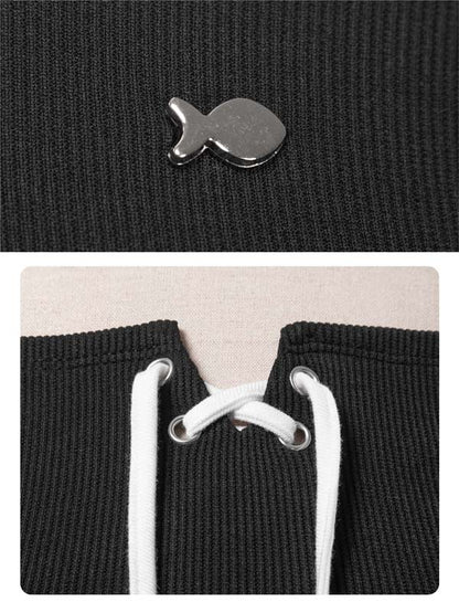Close-up of a black textured fabric with a metal clip and white drawstrings.