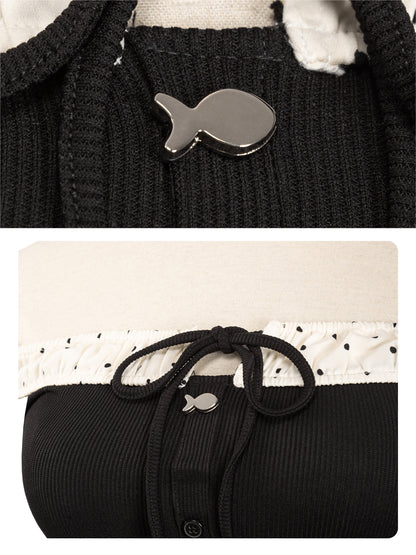 Black sweater with a fish-shaped button on a white background