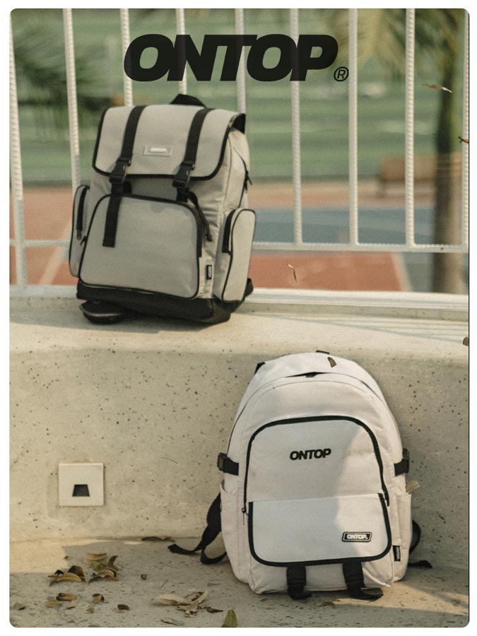 Two backpacks with 'ONTOP' branding on a concrete ledge.