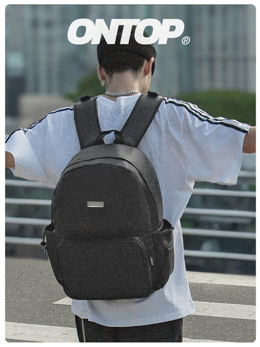 Person wearing a black backpack with 'ONTOP' branding in an urban setting