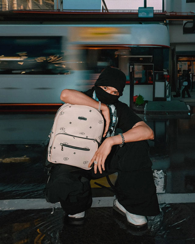 Person sitting on a bench with a backpack in an urban setting