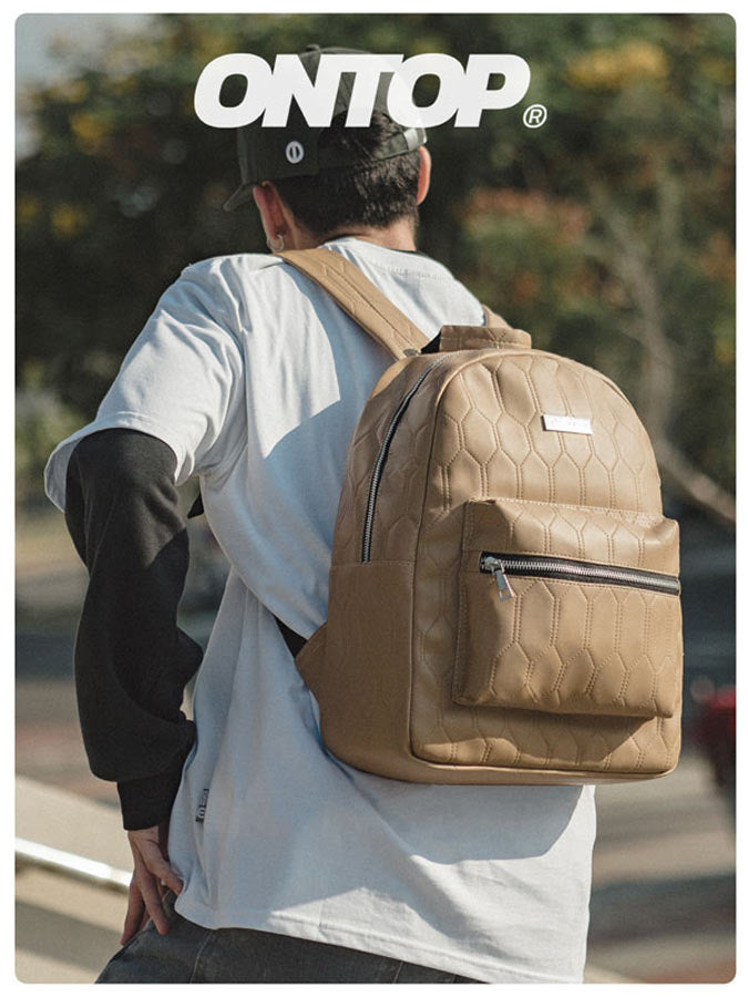 Person wearing a brown backpack with 'ONTOP' branding outdoors.