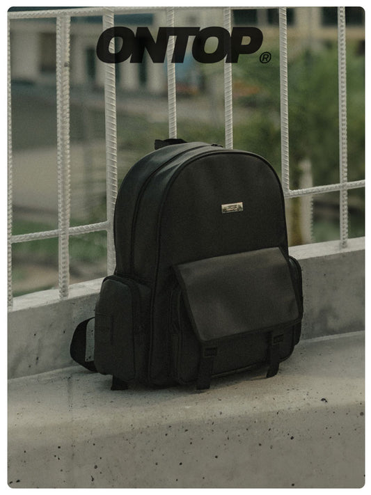 Black backpack on a concrete ledge with 'ONTOP' branding.