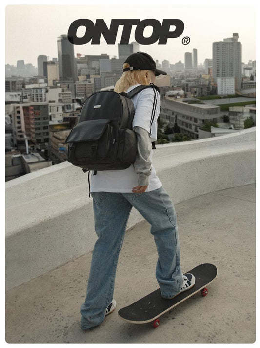 Person with a black backpack and skateboard on a rooftop with a cityscape background, featuring the 'ONTOP' brand.