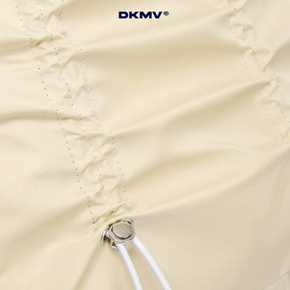 Close-up of a beige umbrella with a visible brand logo in the top right corner.