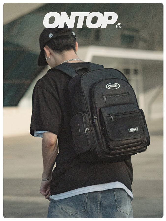 Person wearing a black backpack with 'ONTOP' branding in an outdoor setting