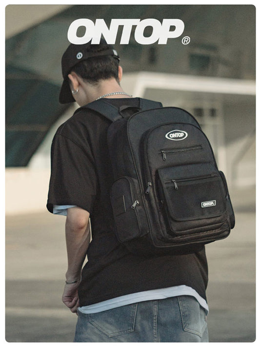 Person wearing a black backpack with 'ONTOP' branding in an outdoor setting
