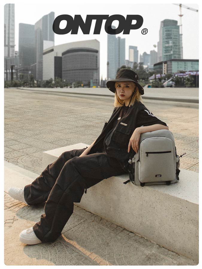 Person sitting with a backpack in an urban setting, featuring the brand 'ONTOP'.