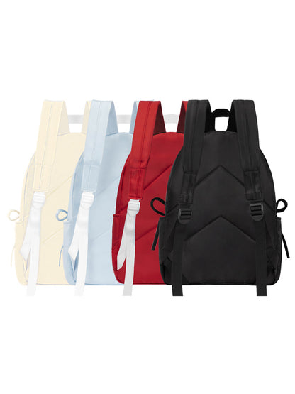 Black backpack among other colorful bags on a white background