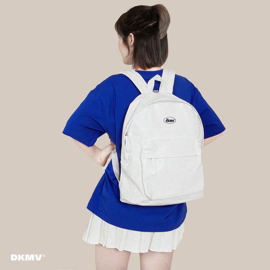 Person wearing a white backpack with a blue outfit on a beige background
