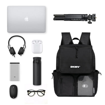 Black backpack with various items including a laptop, headphones, and a water bottle on a white background.