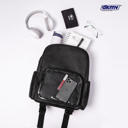 Black backpack with clear front pocket containing a phone, surrounded by earphones, notebook, and wallet on a white background with dkmv branding.