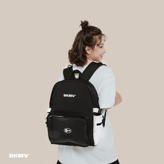 Person wearing a black backpack with 'DKMV' branding on a beige background
