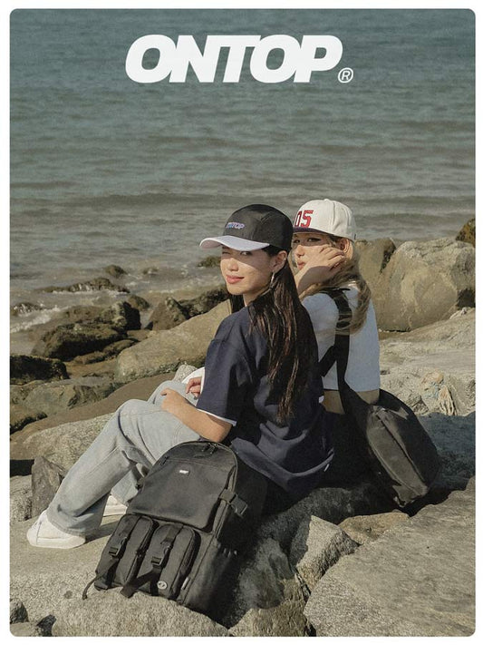 Two people sitting on rocks by the sea with 'ONTOP' logo above.