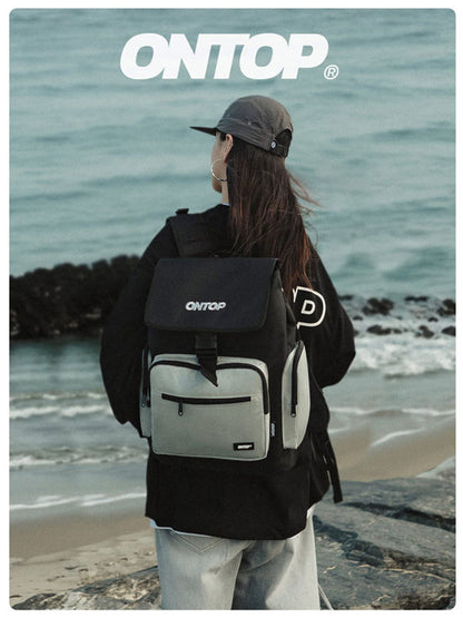 Person wearing an ONTOP backpack on a beach with ocean view
