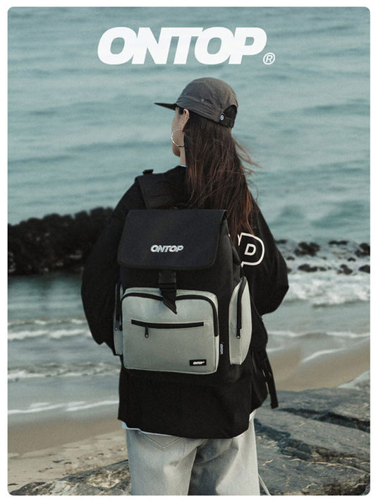 Person wearing an ONTOP backpack on a beach with ocean view