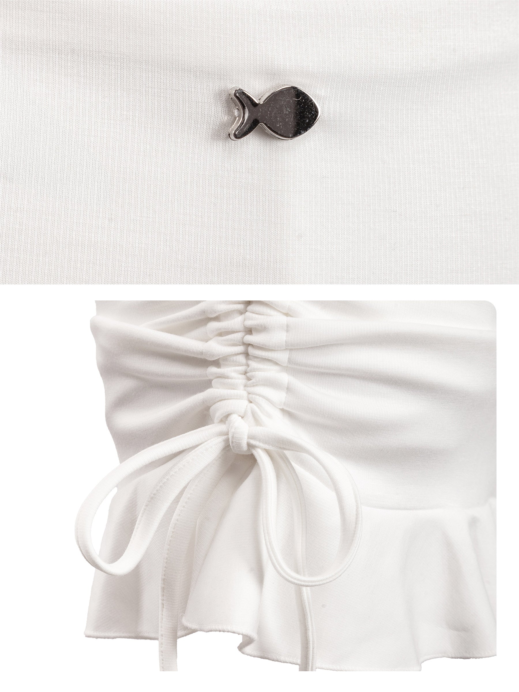 White top with a fish-shaped brooch and white shorts on a white background