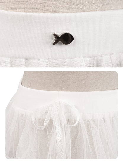 White dress with a black fish-shaped button on a neutral background
