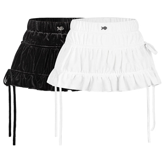 Black and white ruffled skirts with fish appliqués on a white background