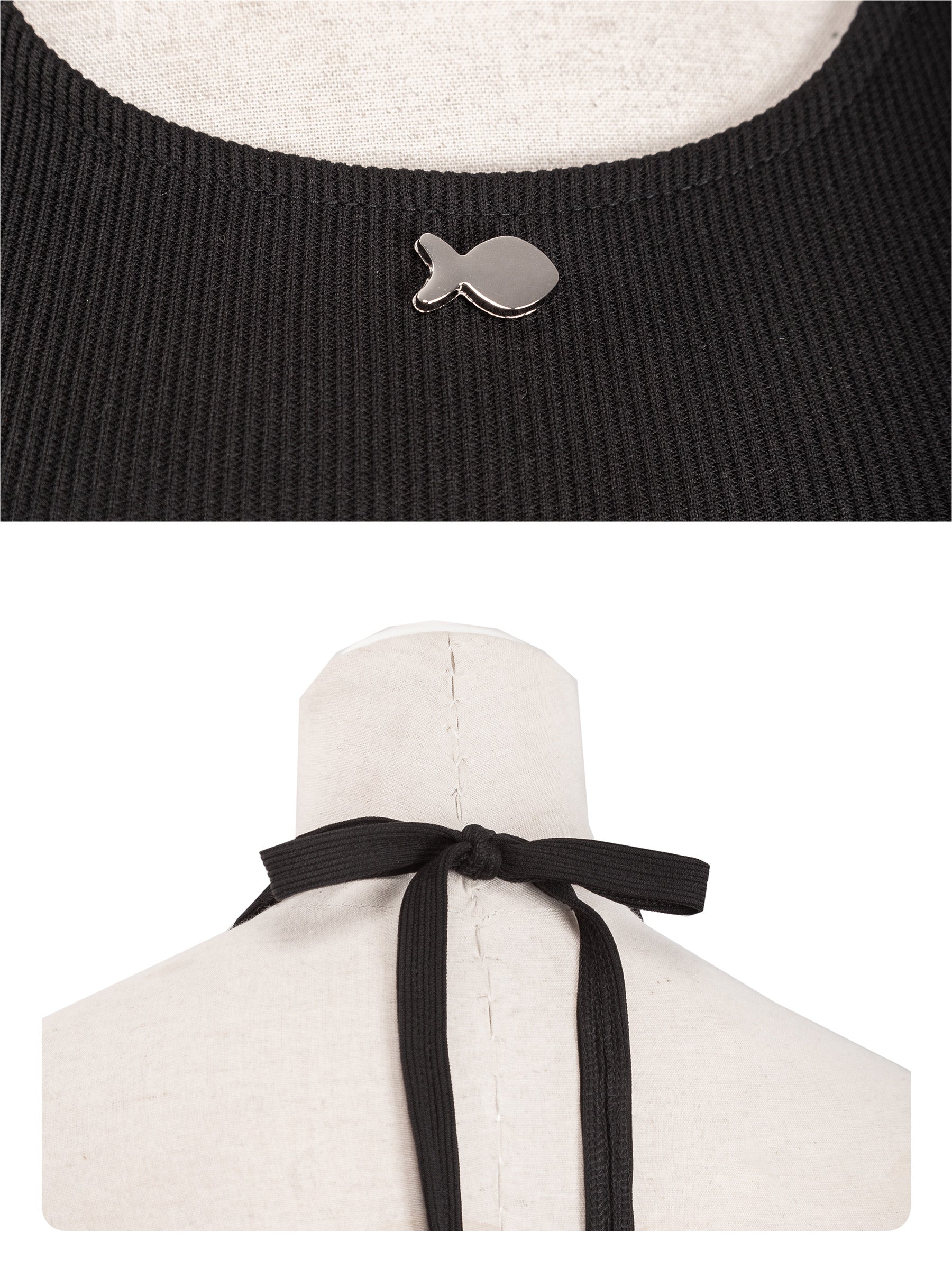 Black sweater with fish-shaped button and white garment with black ribbon on a mannequin.