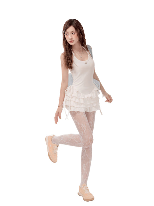 Woman wearing a white outfit with sheer tights on a white background