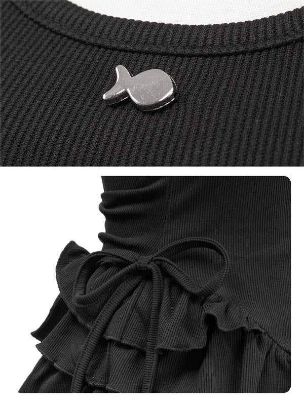 Black ribbed sweater with a fish-shaped button and ruffled hem