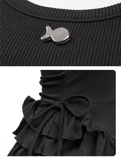 Black ribbed sweater with a fish-shaped button and ruffled hem