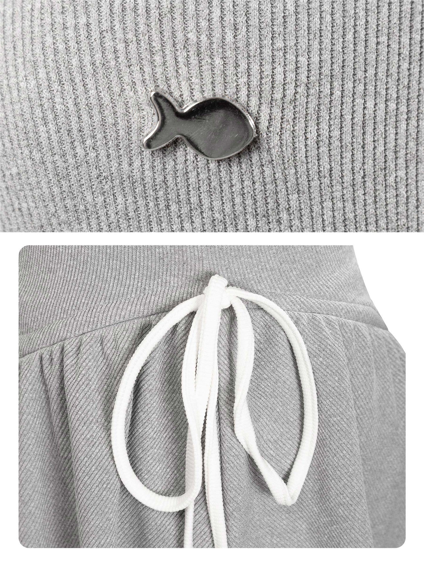 Gray beanie with a small fish-shaped brooch and white drawstrings on a gray background