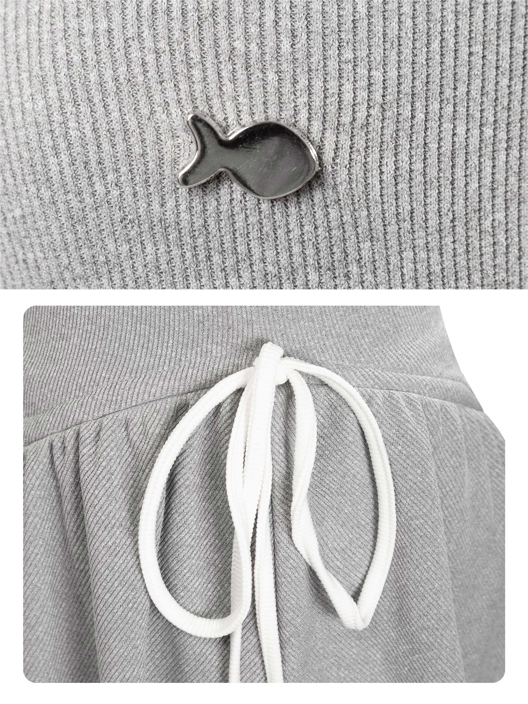 Gray beanie with a small fish-shaped brooch and white drawstrings on a gray background