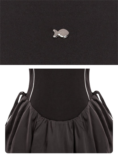 Black dress with a fish-shaped brooch on a white background