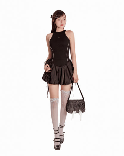 Woman wearing a black dress with a skirt, stockings, and shoes on a white background