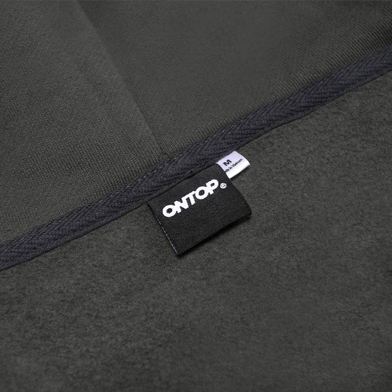 Close-up of a dark gray fabric with a brand label on a black background