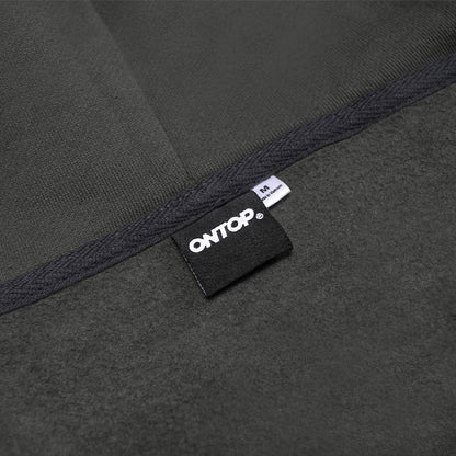 Close-up of a dark gray fabric with a brand label on a black background